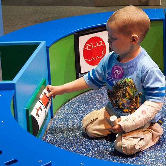 toddler playing with a train spinner